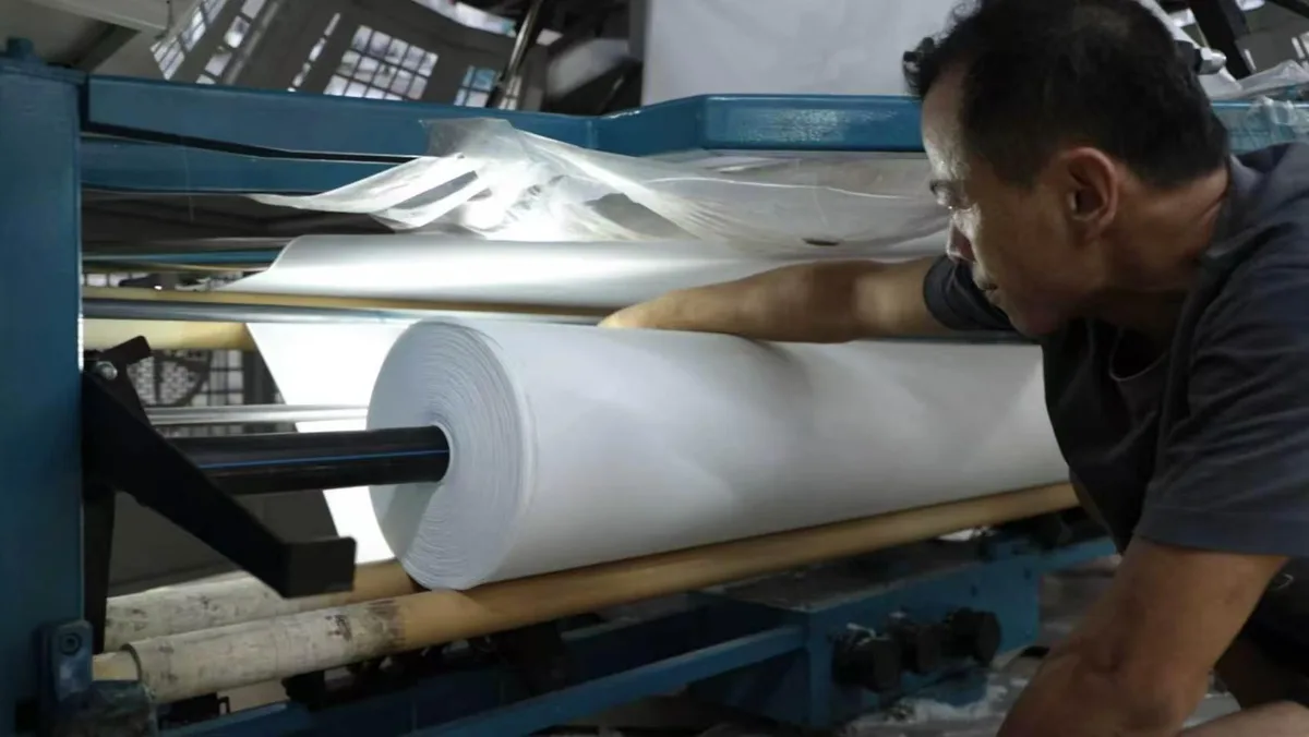 Technician inspecting fabric during textile finishing production