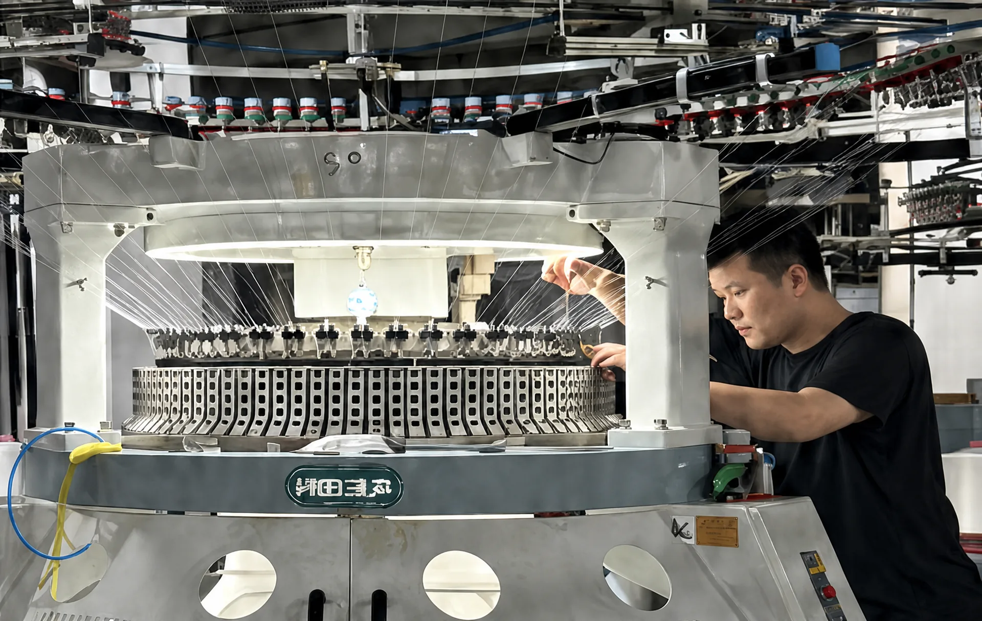 Circular knitting machine producing knitted synthetic stretch fabric